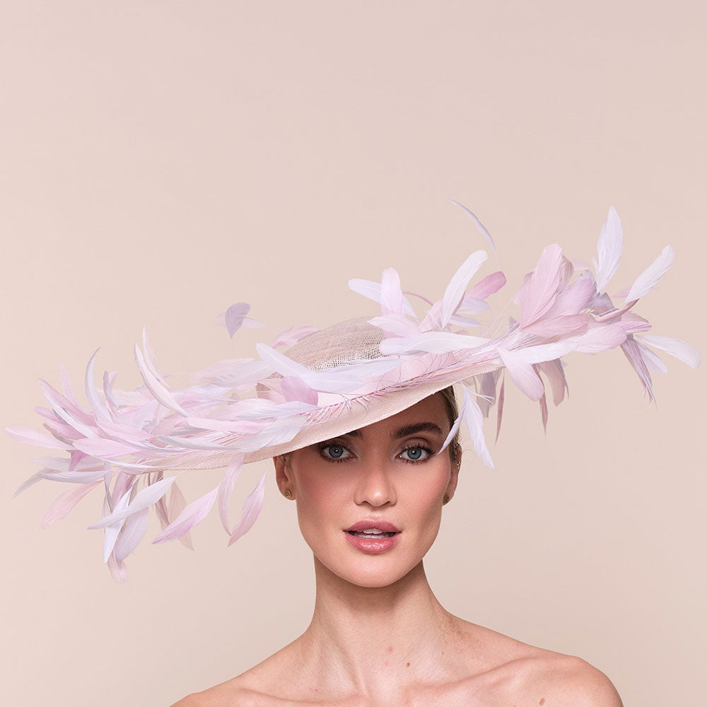 Luxury Kentucky derby hat. Woman wearing a pink feathered hat against a beige background