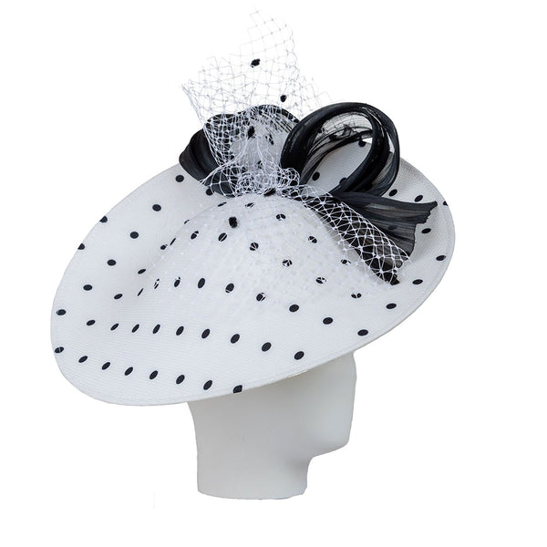 White luxury hat with black polka dots and decorative black bow on a white background