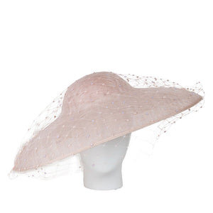 Luxury designer hat large pink hat with a veil on a mannequin head against a white background