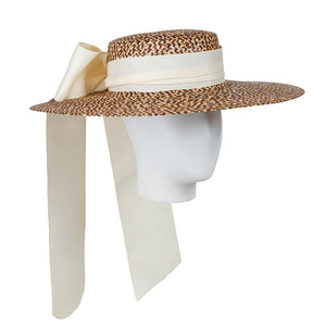 Wide-brimmed straw hat with a white ribbon on a mannequin head against a white background