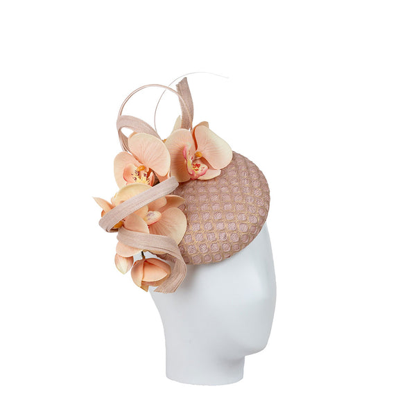 Pink floral headpiece on a mannequin head against a white background