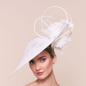 Ladies high end hat. Woman wearing a white decorative hat against a beige background